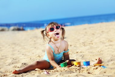 Child playing at the beach clipart