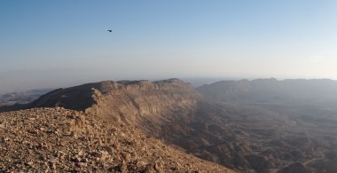 Rim of desert canyon at sunset clipart