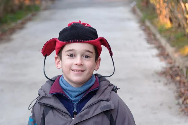 Sevimli küçük çocuğun kafasına komik bir şapka sonbaharda açık — Stok fotoğraf