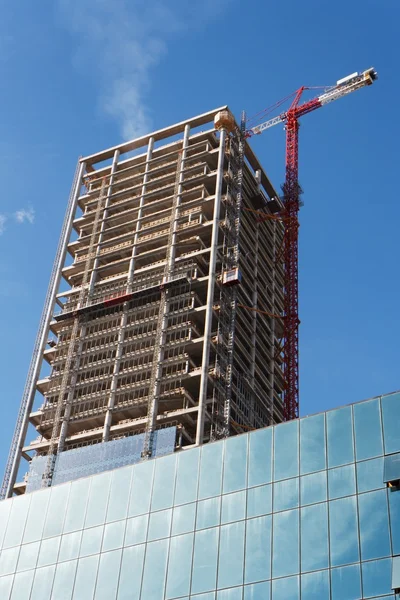 Opheffing van de kraan en hoge gebouw in aanbouw — Stockfoto