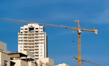 Lifting crane and apartment building under construction clipart