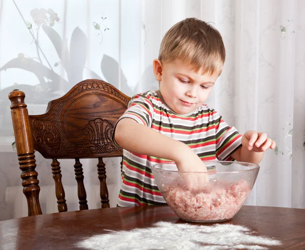 A boy is mixing mincemeat in a bowl — Stock Photo, Image