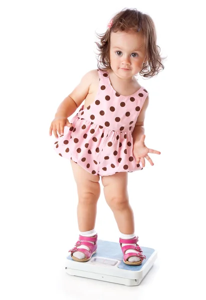 A little girl is standing on the scales — Stock Photo, Image