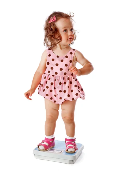 Маленькая девочка стоит на весах — стоковое фото