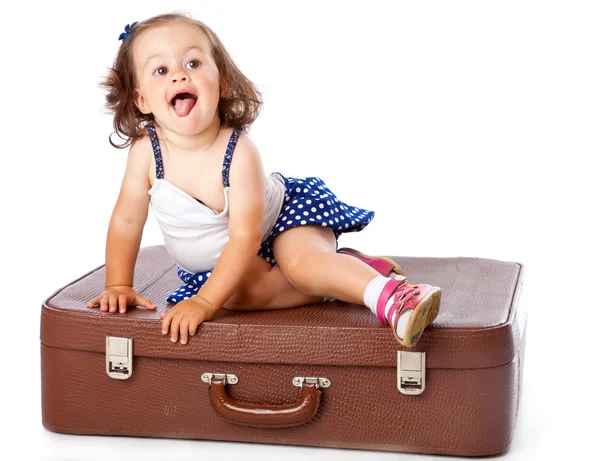 Ein kleines Mädchen auf dem Koffer — Stockfoto