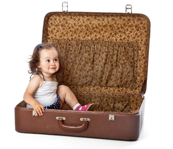 A girl is sitting in a suitcase. — Stock Photo, Image