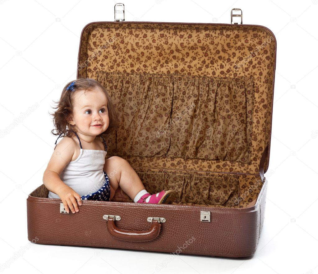 A girl is sitting in a suitcase.