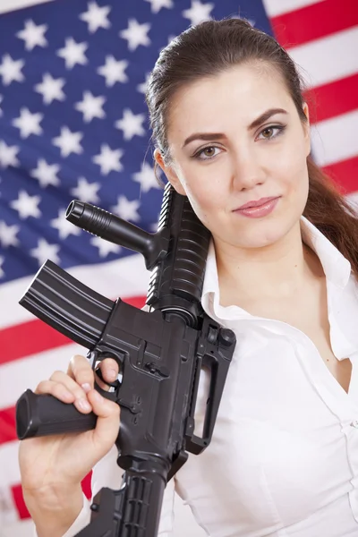 Femme patriotique avec arme sur drapeau américain — Photo
