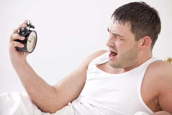 Kızgın adam yatakta ile çalar saat — Stok fotoğraf