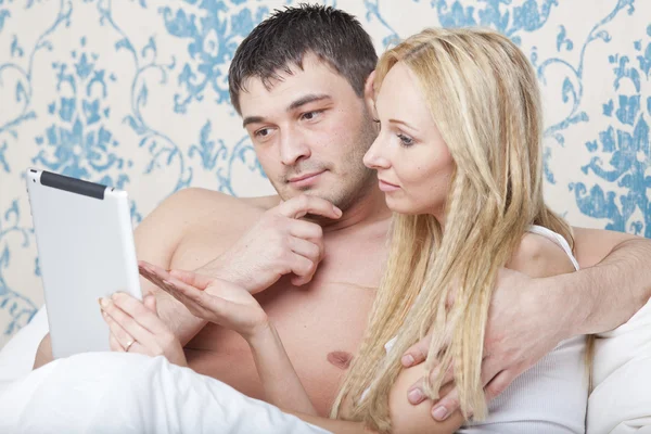 Casal na cama com computador tablet — Fotografia de Stock