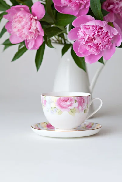 Teacup and pink peonies — Stock Photo, Image