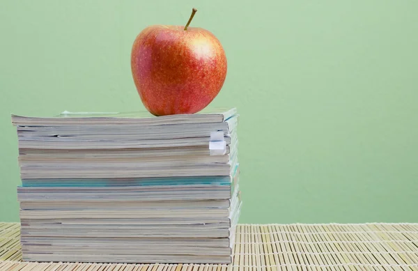 Stack of magazines and red apple — Stock Photo, Image