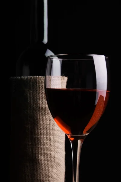 Бутылка с красным вином и бокалом — стоковое фото