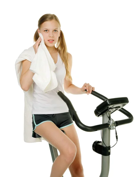Girl with gym bicycle — Stock Photo, Image