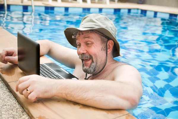 Людина в басейні з ноутбуком — стокове фото