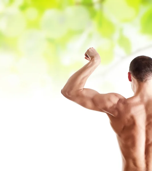 Bodybuilder zeigt seinen Bizeps über Grün — Stockfoto