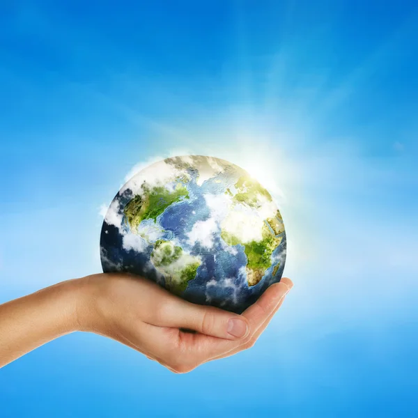 Hand hält Globus über blauem Himmel - Elemente dieses Bildes furnis lizenzfreie Stockfotos