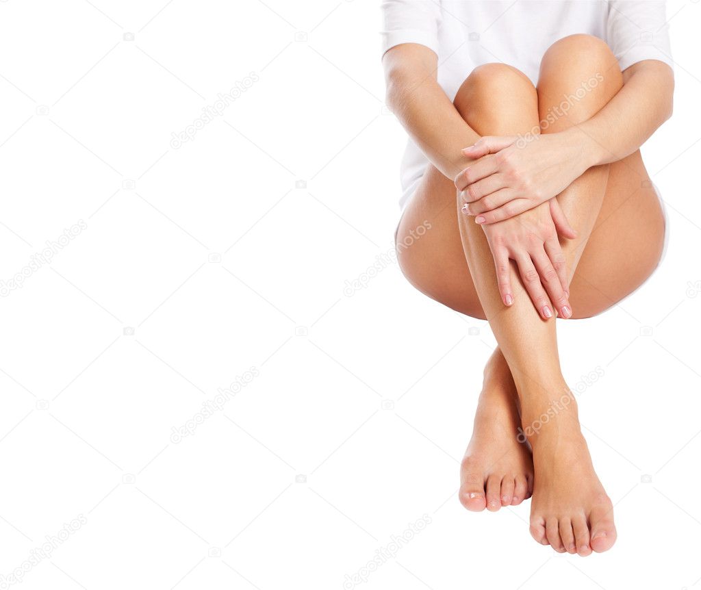 Cut out slender naked female legs being massaged isolated on whi