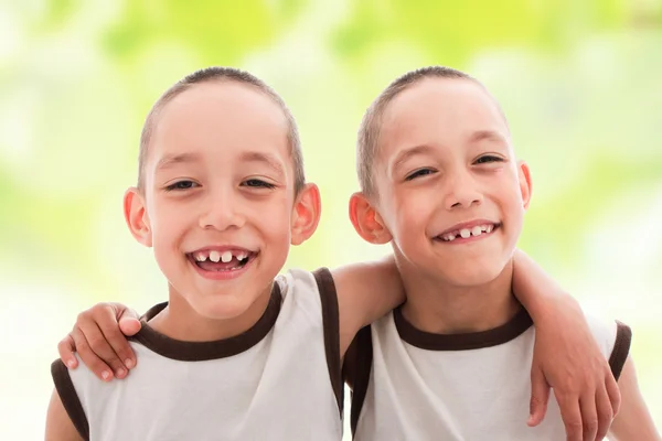 Dwa uśmiechający się zadowolony chłopcy bliźniaki — Zdjęcie stockowe