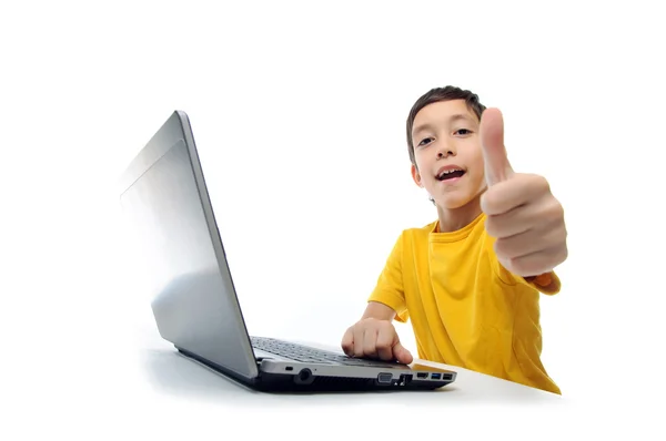 Niño en camiseta amarilla con portátil mostrando los pulgares hacia arriba en la leva —  Fotos de Stock