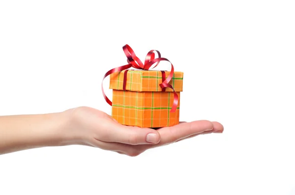Female hand holding red and yellow gift box with a bow isolated — Stock Photo, Image