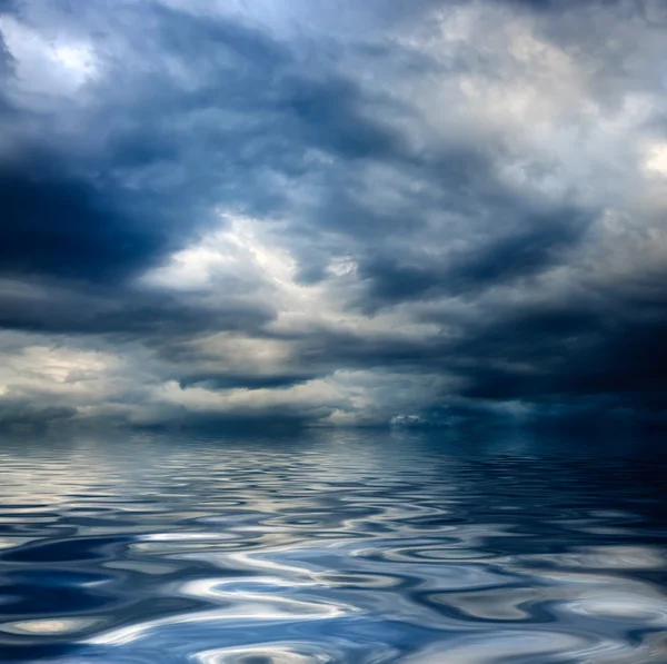 Oscuro cielo nublado y tormentoso con nubes y olas en el mar —  Fotos de Stock