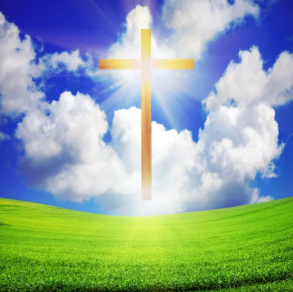 Easter cross over green field and blue sky Stock Photo