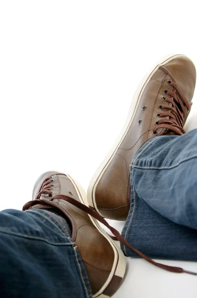 Mužské nohy hnědé boty tenisky a džíny — Stock fotografie