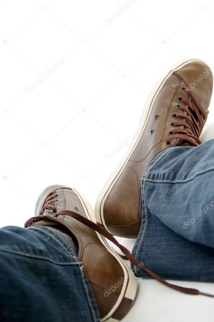 Male legs in brown shoes sneakers and jeans