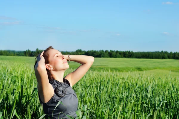 Kvinna med händerna upp upp i fältet vete — Stockfoto