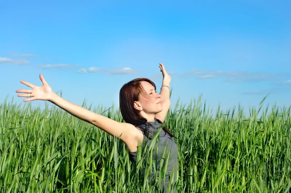 Woman with hands raised up in the wheat field — Stockfoto