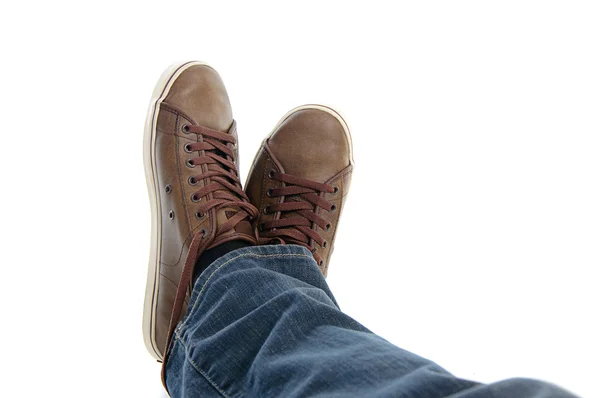 Piernas masculinas en zapatillas y jeans acostados — Foto de Stock