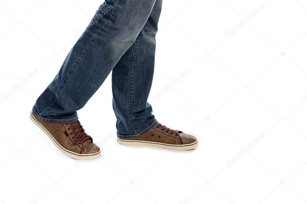 Male legs in jeans and brown sneakers shoes