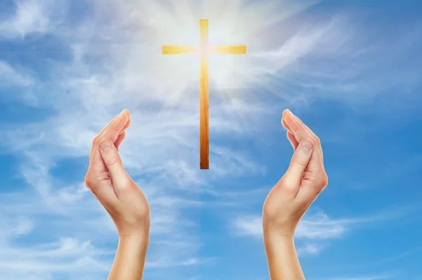 Mãos rezando com uma cruz de madeira — Fotografia de Stock