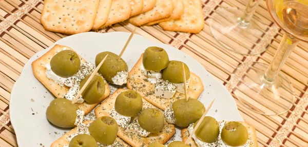 Crackers with olives and cheese feta and two glasses of wine — Stock Photo, Image