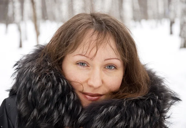 Brunette woman in snow winter park — Stockfoto