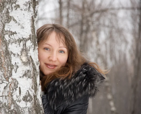 Brunett kvinna i snö vinter park — Stockfoto