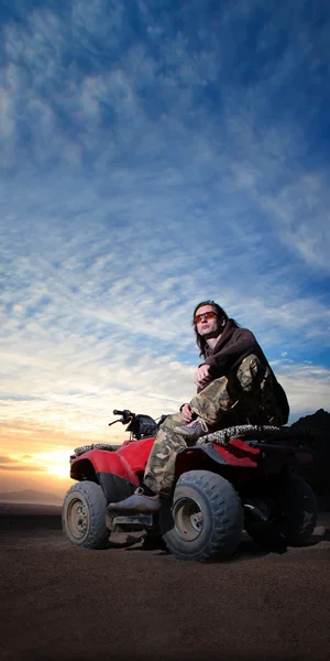 砂漠の日の出背景に atv の男 — ストック写真