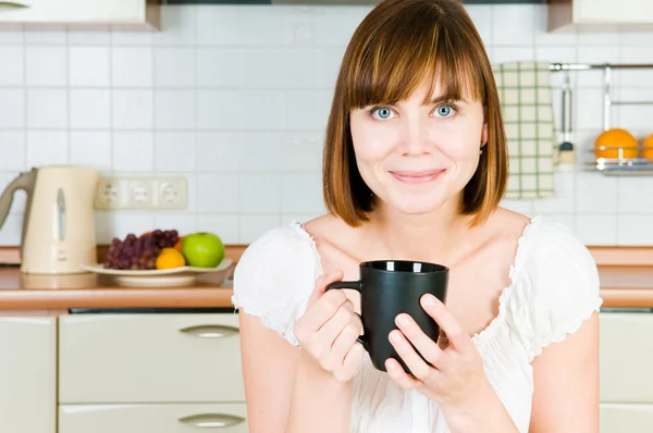 Junge erfolgreiche Frau bei einer Tasse Kaffee zu Hause. — Stockfoto