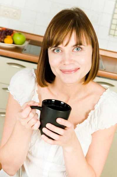 Młoda kobieta sukces, cieszyć się filiżanką kawy w domu. — Zdjęcie stockowe