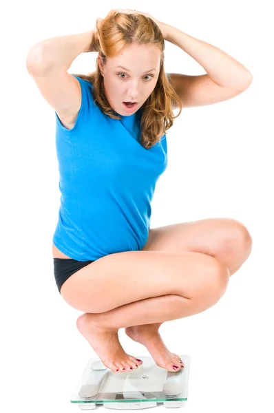 Uma jovem grita enquanto vê seu peso na balança — Fotografia de Stock
