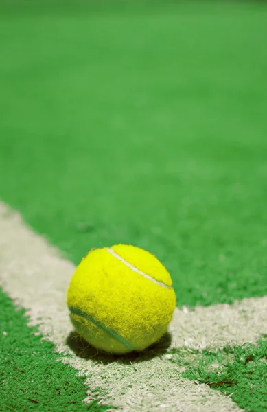 Tennis ball on the court line — Stock Photo, Image