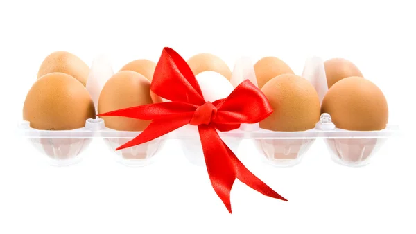 Vita ägg virad runt med rött band och pack — Stockfoto