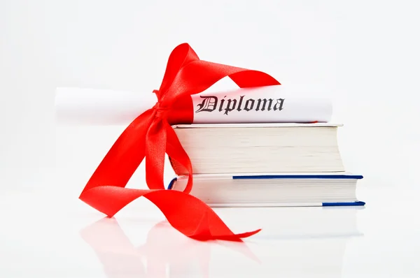 Diploma with red ribbon and books — Stock Photo, Image