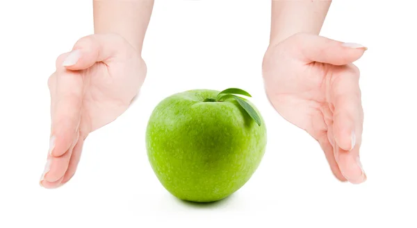 Green apple between open hands — Stock Photo, Image