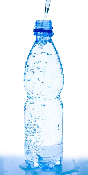 Наливая воду из бутылки на белое — стоковое фото