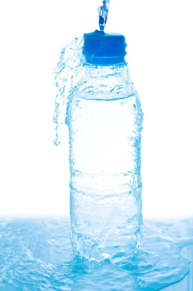 Наливаємо воду з пляшки на білому — стокове фото