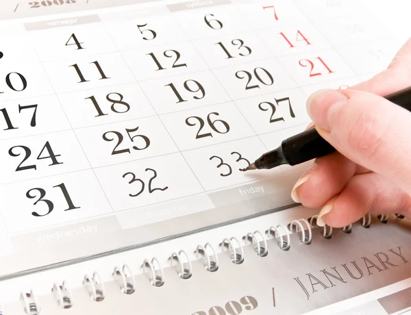 Mão, adicionando números em um calendário — Fotografia de Stock