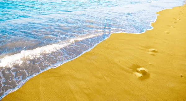 Złoty piasek na plaży i błękitne fale — Zdjęcie stockowe