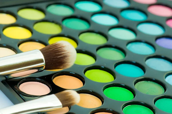 Multicolored eye shadows with cosmetics brush — Stock Photo, Image